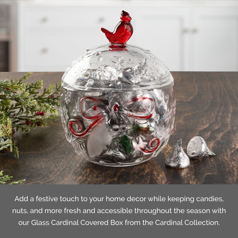 Lidded glass candy jar decorated with a skull motif and red ribbon accents, finished with a red cardinal finial.