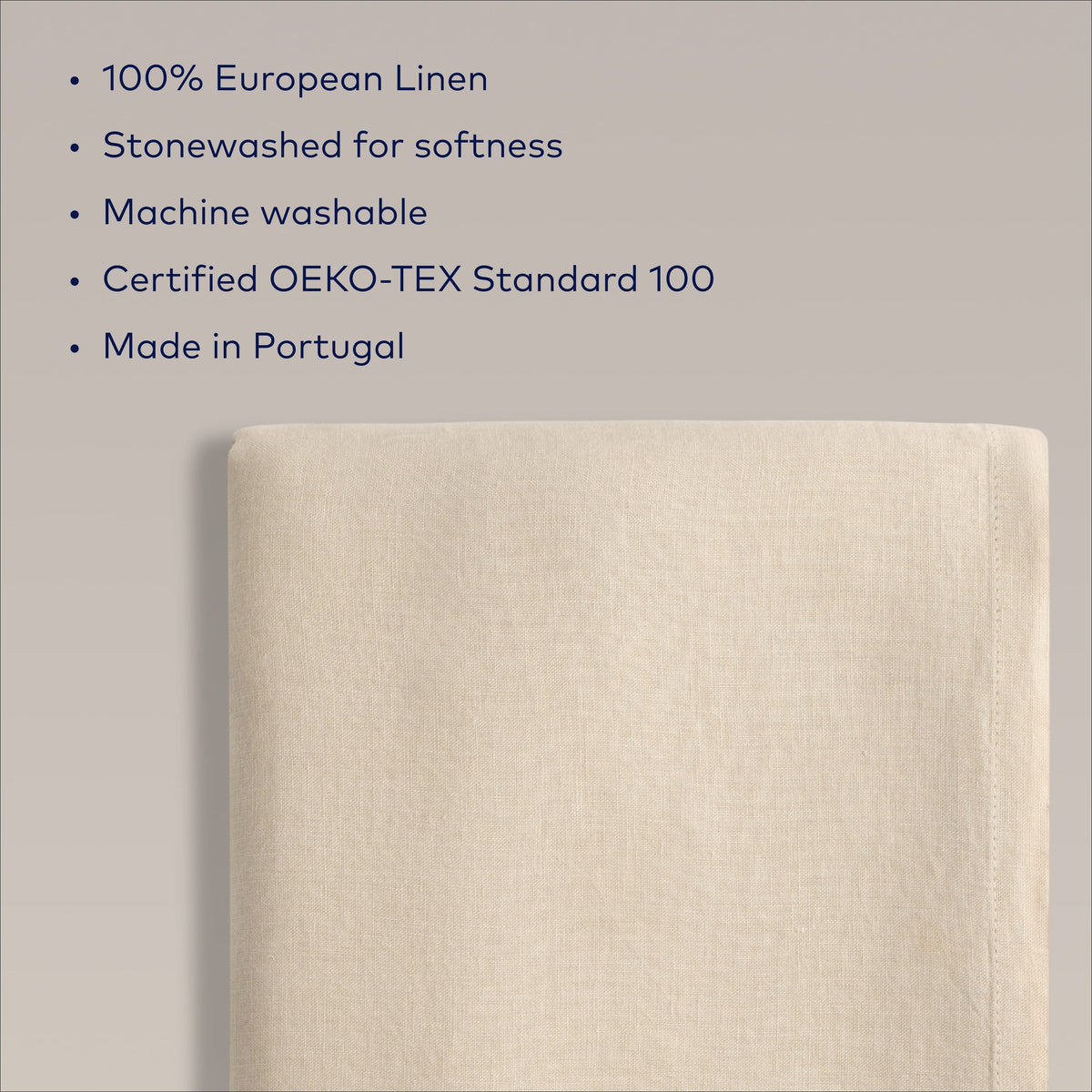 Close up of Dune Beige European Linen fabric showing subtle weave and finished edge