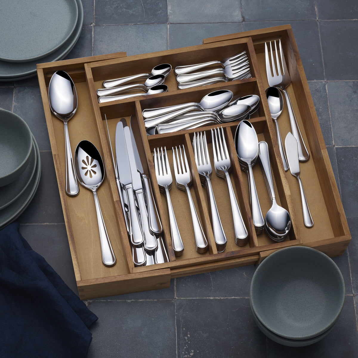Close up of polished forks knives and spoons in a wooden cutlery tray