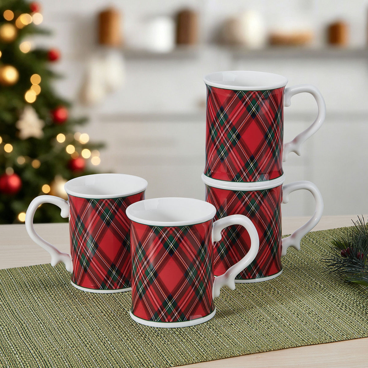 Tartan red mugs arranged on a table in a cozy kitchen setting with a Christmas tree blurred in the background