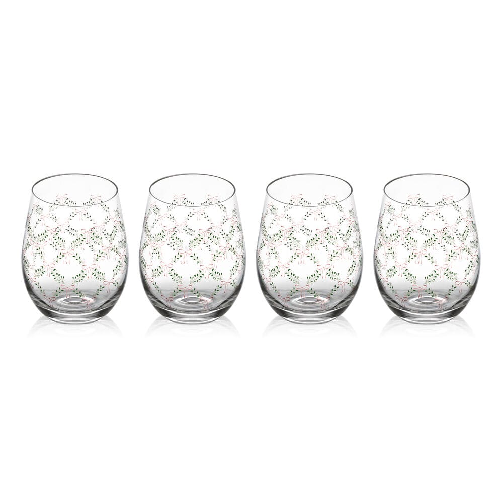 Set of four stemless wine glasses with green garland and red bow pattern, arranged on a white backdrop.