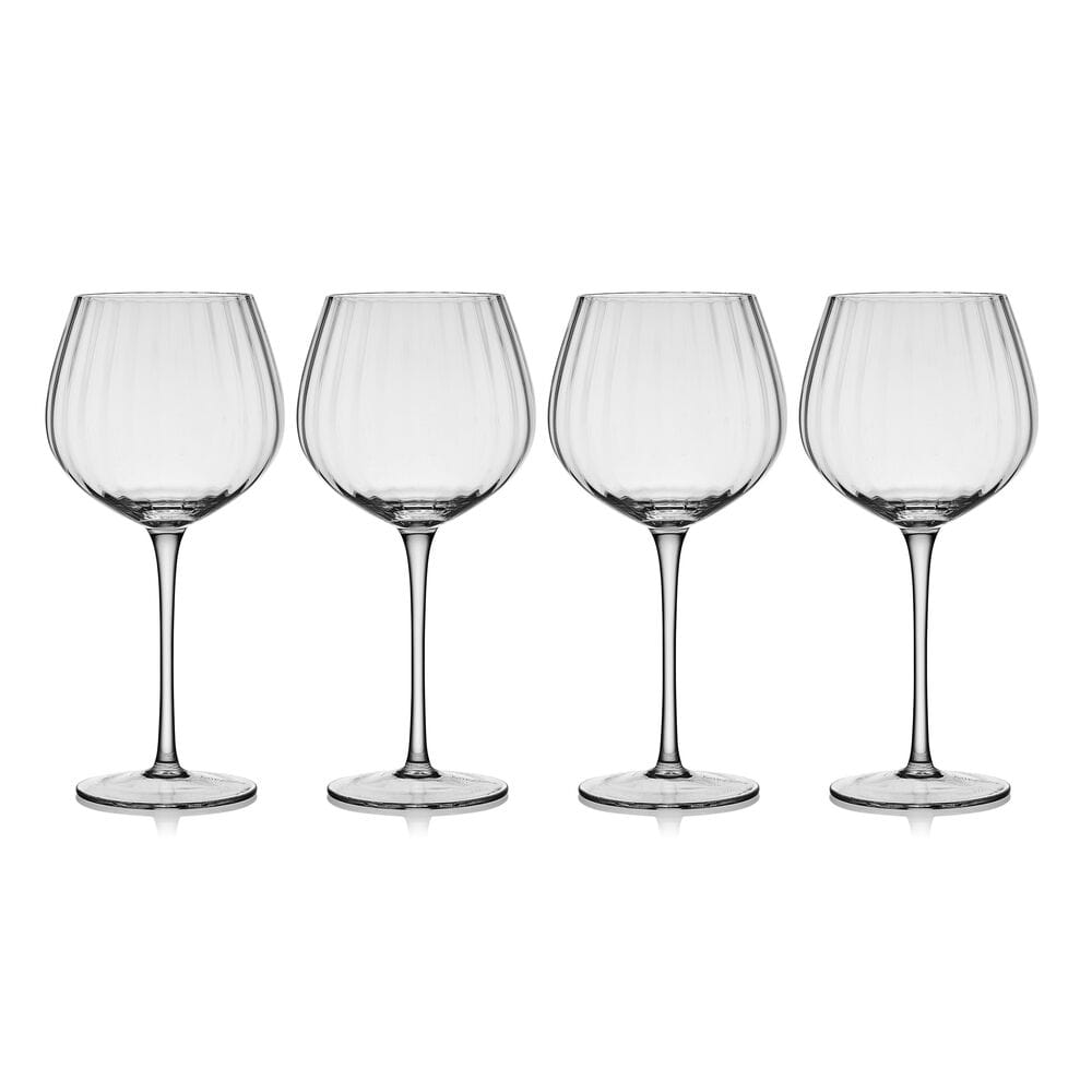 Four optic wine glasses lined up on a white background.