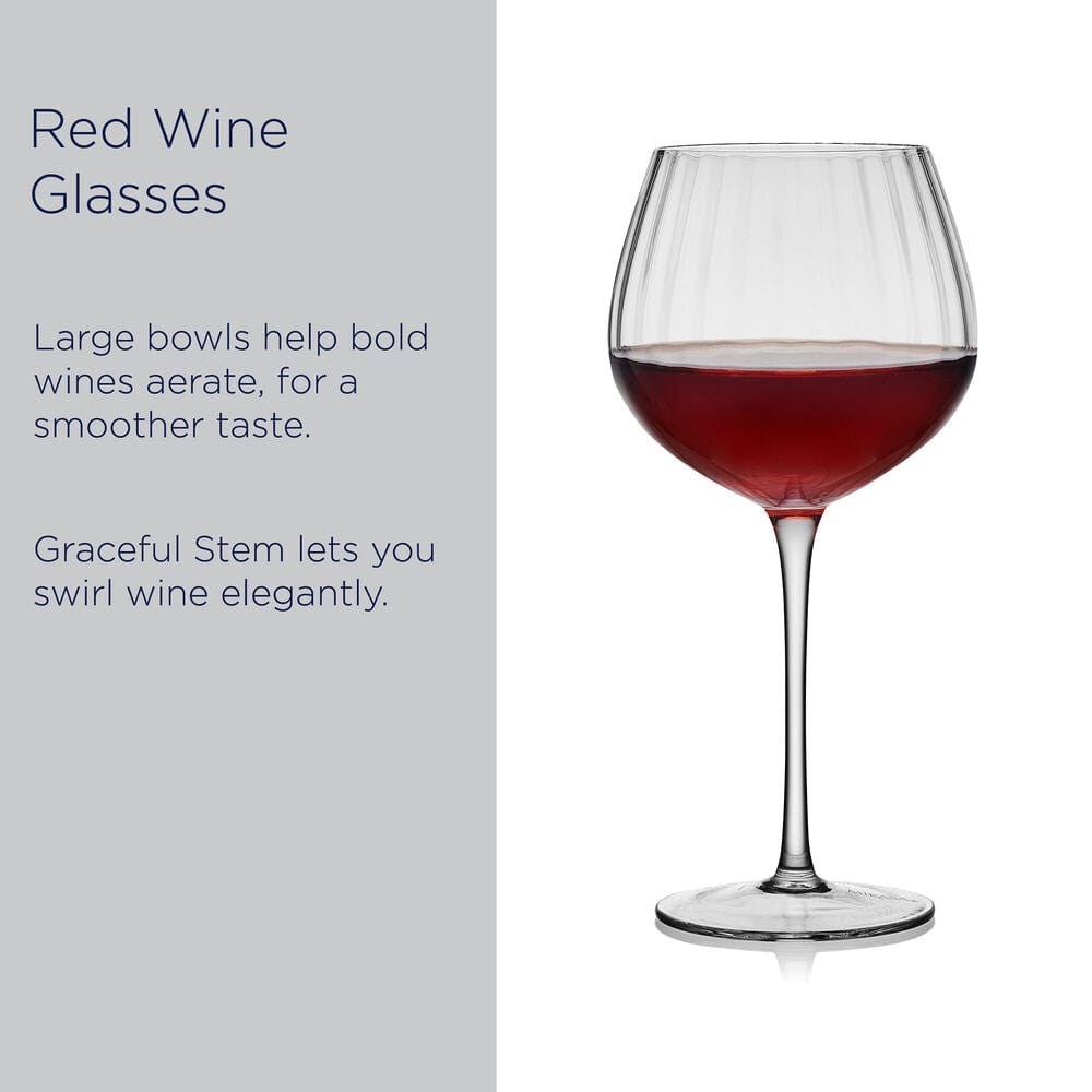 Optic red wine glass filled with red wine against a light gray panel