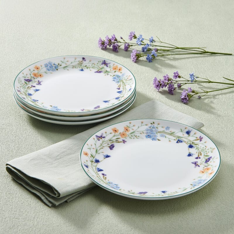Quinn floral border appetizer plates stacked with a single plate beside a linen napkin and lavender sprigs