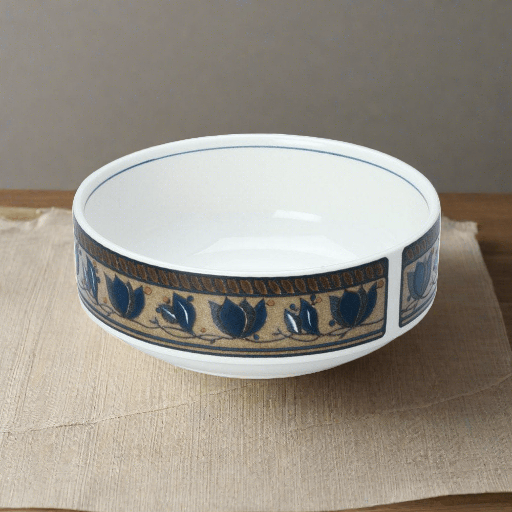 Arabella soup cereal bowl with blue floral border on a tan band around the exterior resting on a beige placemat.