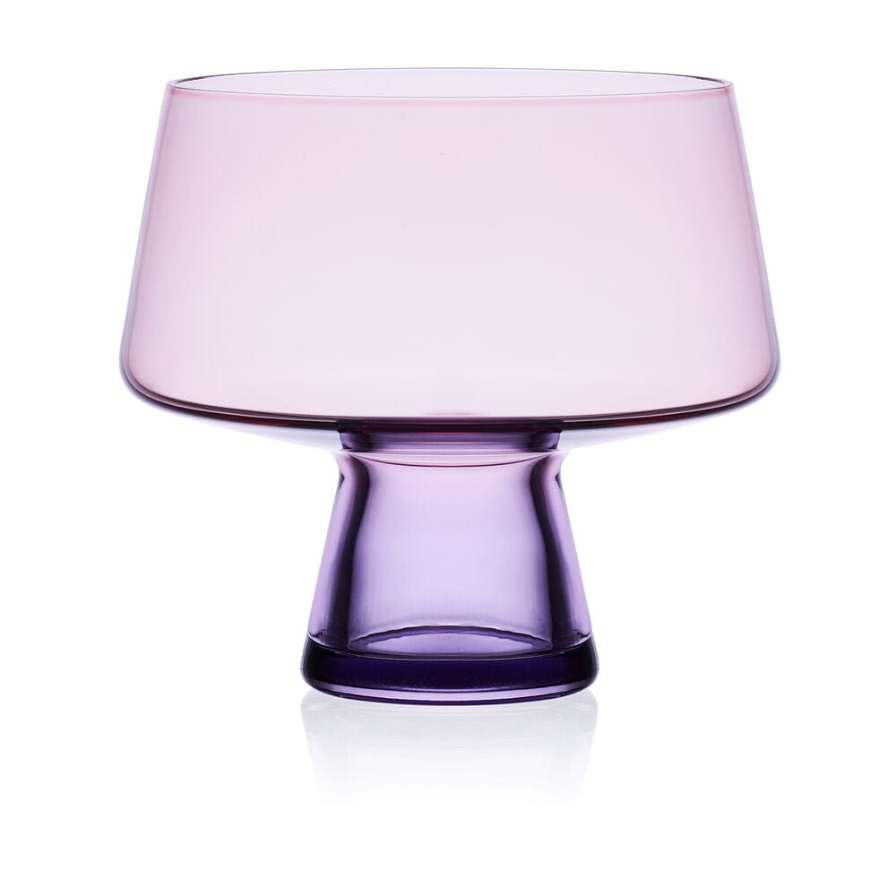 Pink translucent martini glass with a short purple pedestal base on a white background