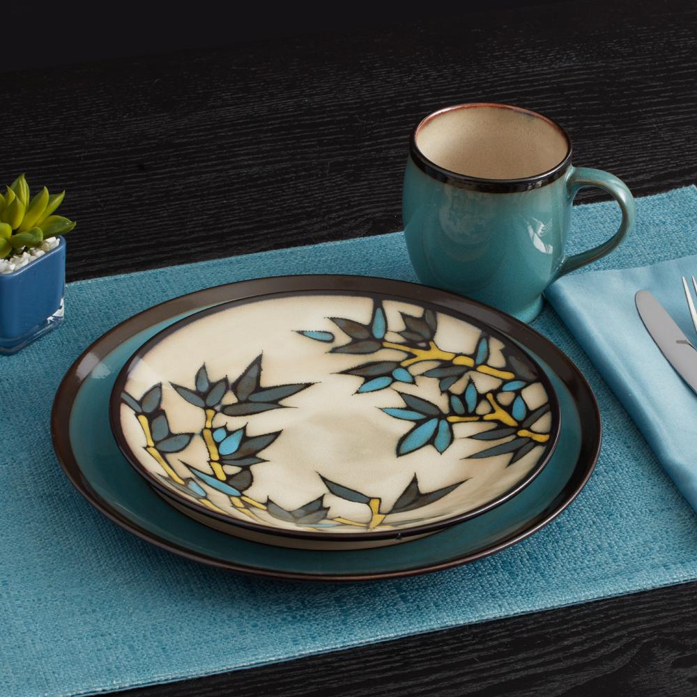 Table setting with a Belmont stalks salad plate on a teal charger, turquoise mug, and blue napkin
