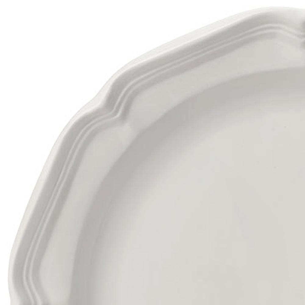 Close-up of a white dinner plate edge with a scalloped rim