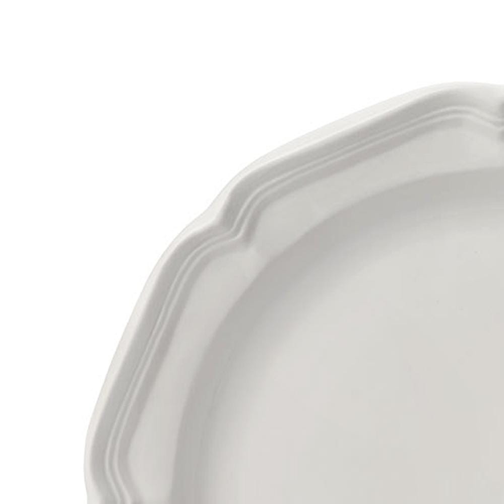 Close up of a white salad plate edge with a scalloped rim from French Countryside
