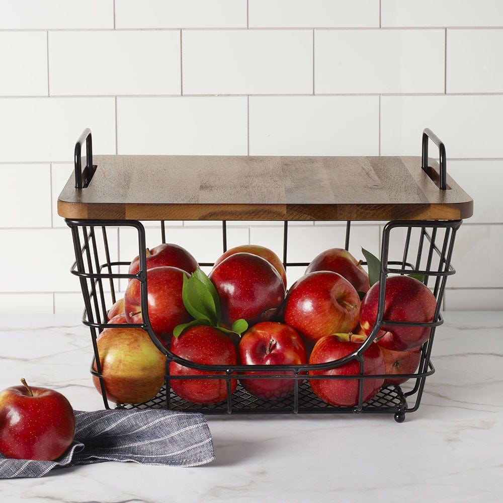Madam stacking and nesting basket filled with red apples on a marble countertop with white tile backdrop