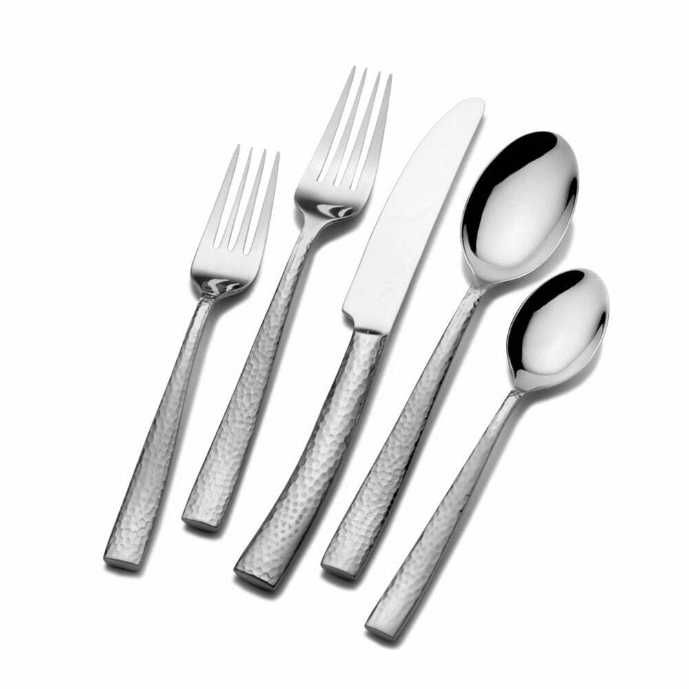 Texture 20 piece flatware set for four with hammered stainless handles arranged on a white background
