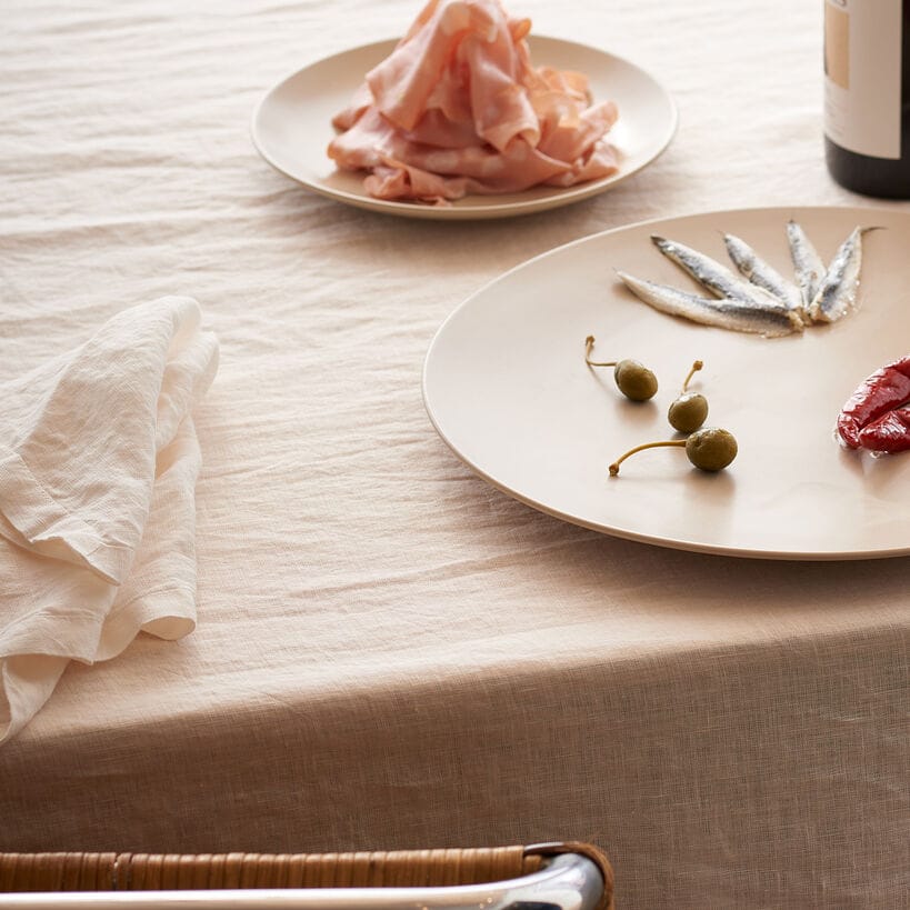 Moon White European Linen 55 x 110 tablecloth on a table with plates olives and ham