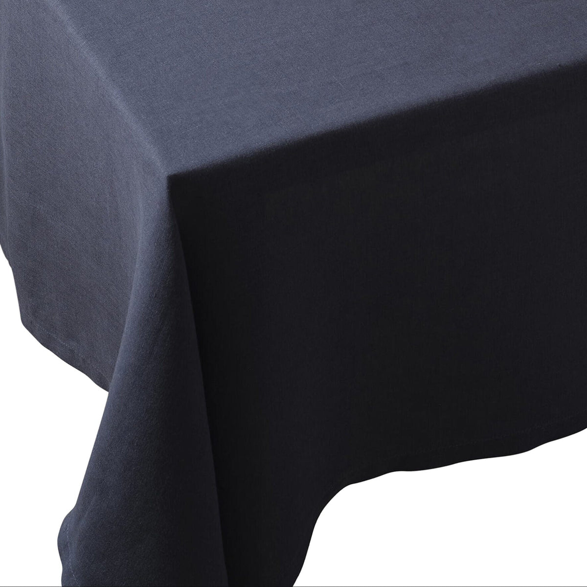 Midnight off-black European linen tablecloth draped over a corner of a table showing deep color and texture.
