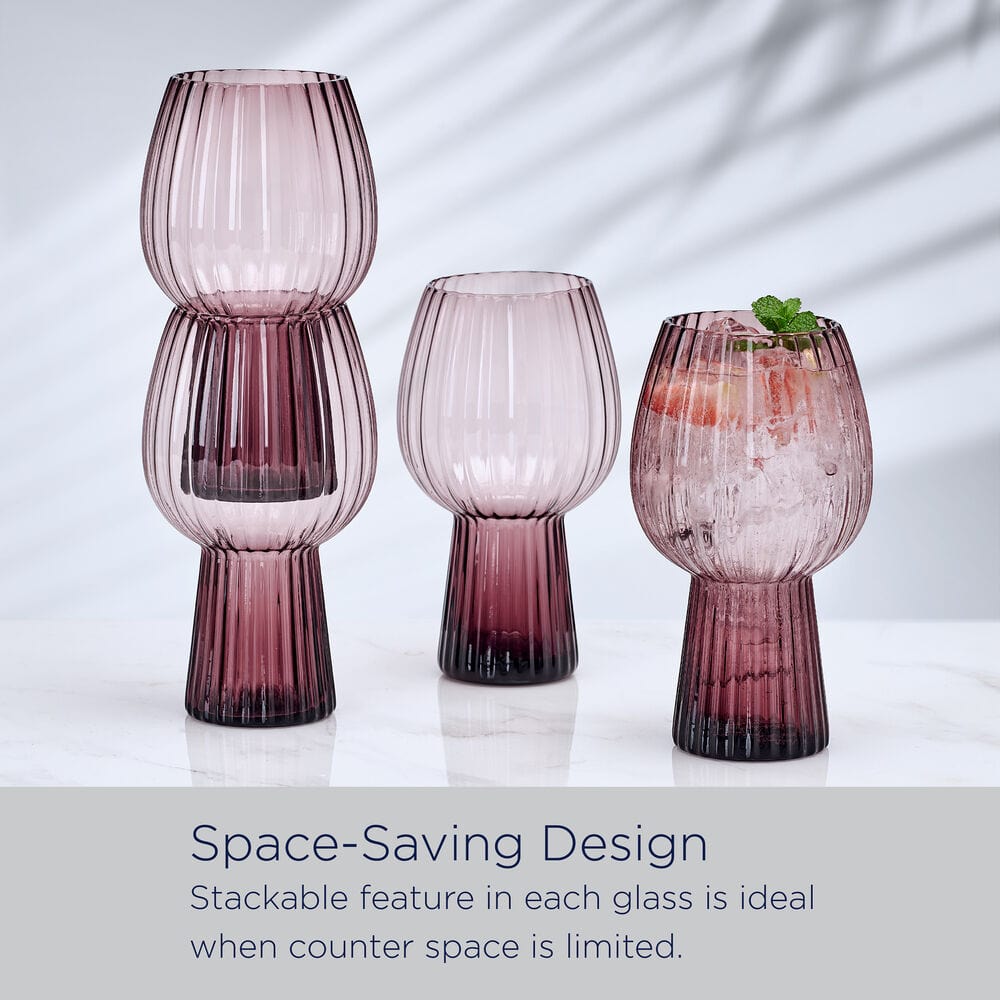 Three lilac ribbed goblet glasses arranged on a white surface, two stacked to form a column and the third containing a beverage