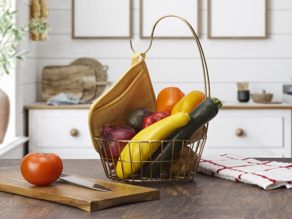 Geneva Gold Fruit Storage Basket with Banana Hook filled with bananas apples pears and oranges on a kitchen counter