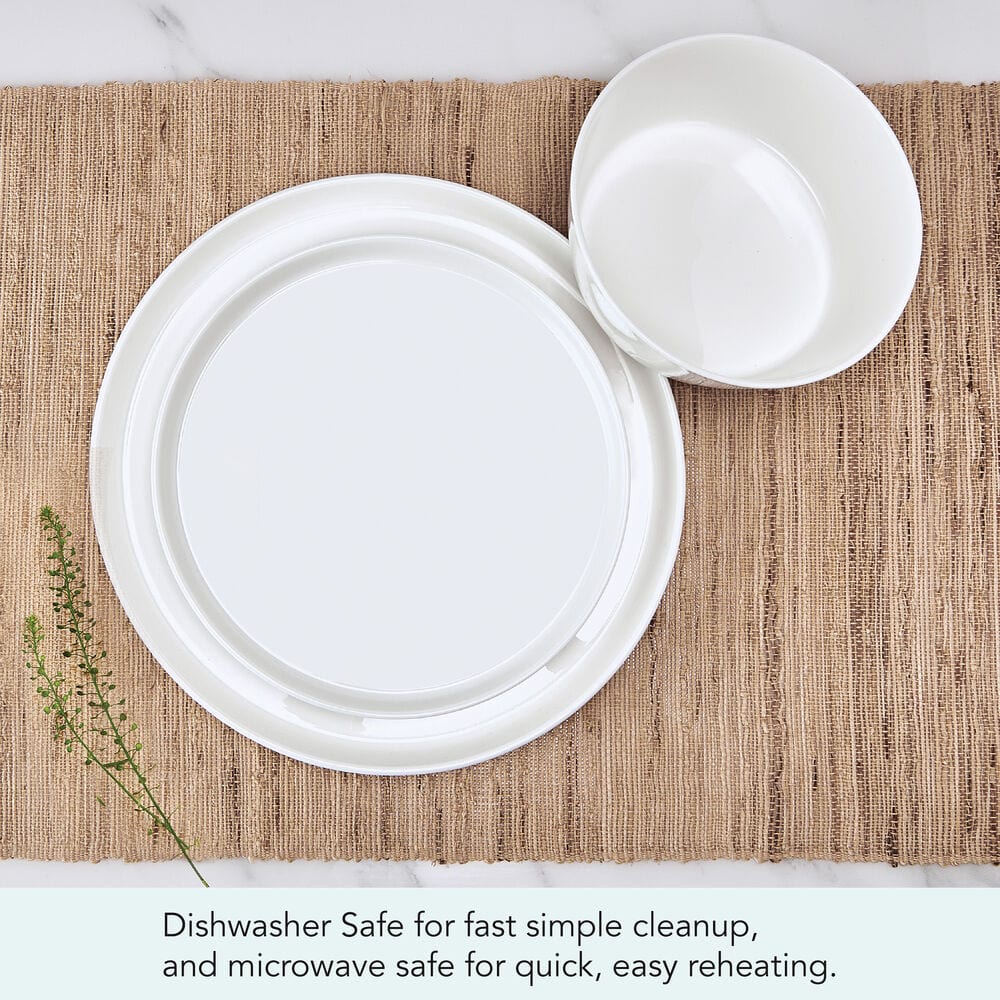 White Rylee dinnerware set for four with plates and bowls displayed on a woven placemat.