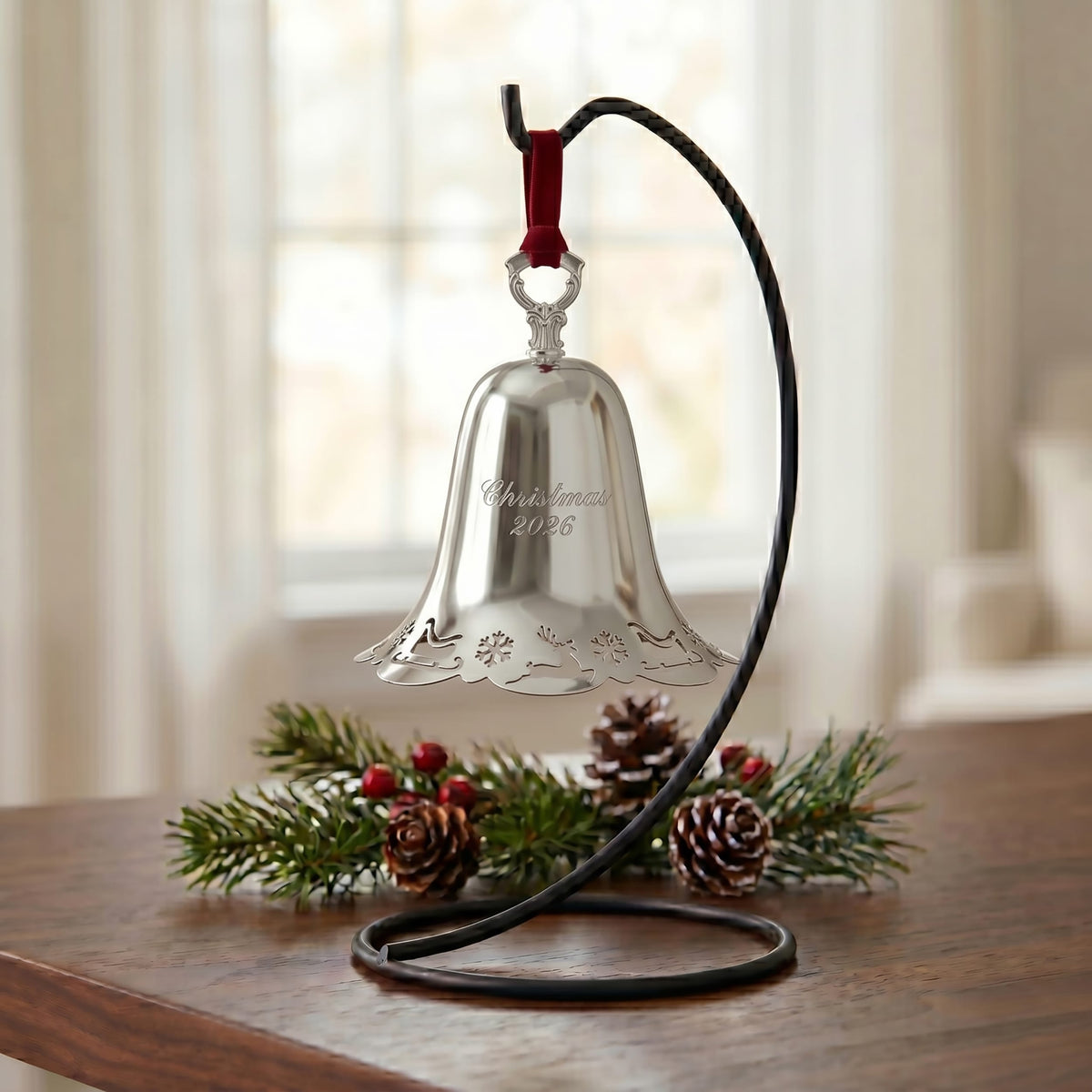 Towle 2026 silver plated pierced bell ornament hanging from a red ribbon