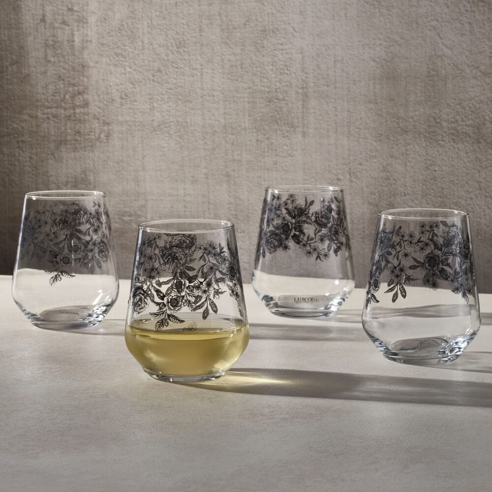 Windsor Rose set of four stemless wine glasses with black floral print; one glass filled with white wine