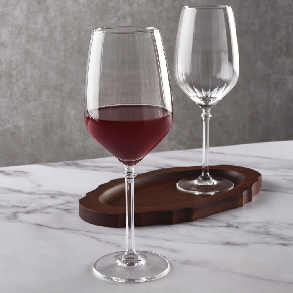 Eloise set of two ribbed wine glasses on a marble surface with one filled with red wine