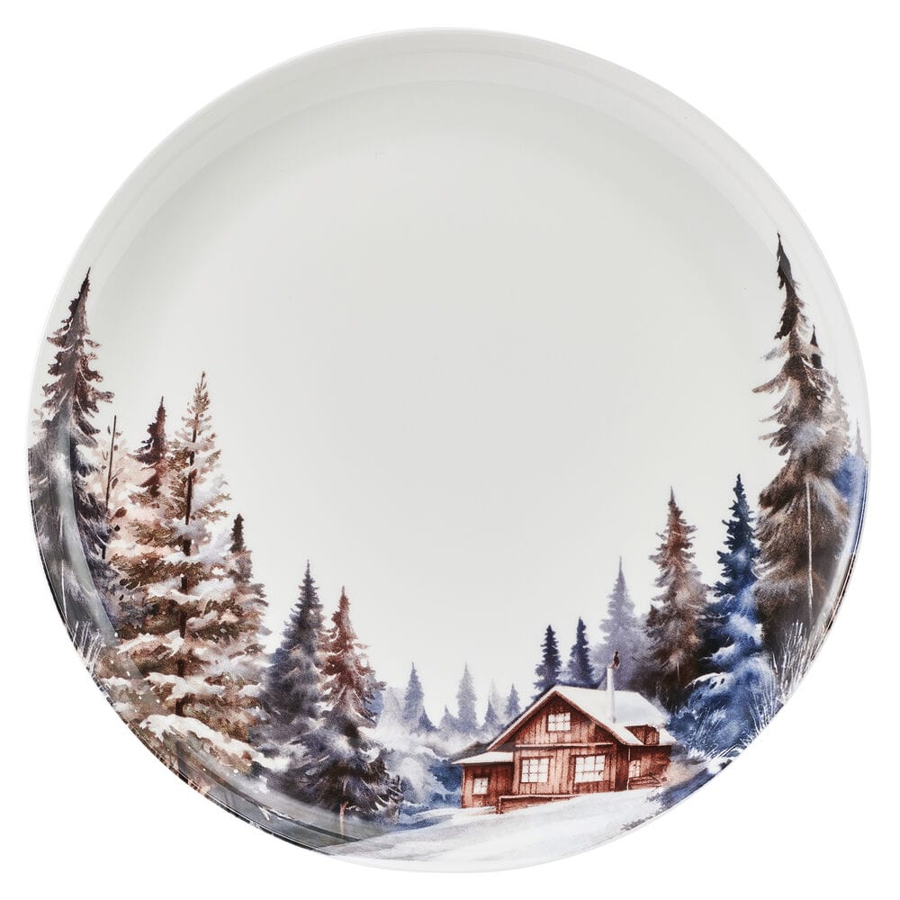 Round dinner plate from Whispering Pines set featuring a snowy forest with a cabin along the edge