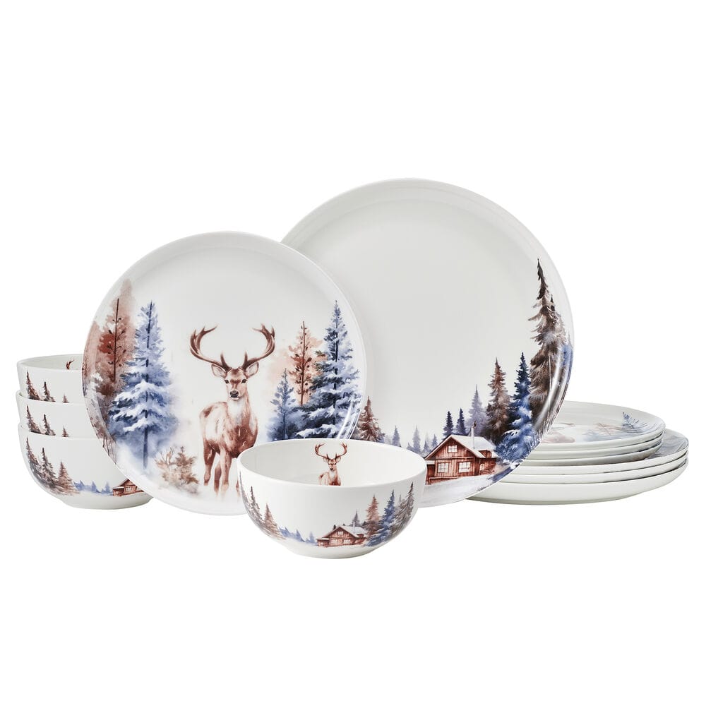 Whispering Pines dinnerware set for four with plates bowls and mugs featuring a winter forest scene with a deer