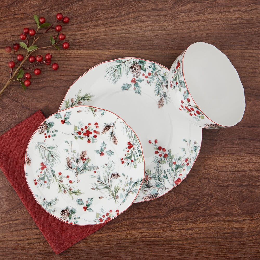 Pine and Berry dinnerware set arranged on a wooden table with patterned plates and a bowl.