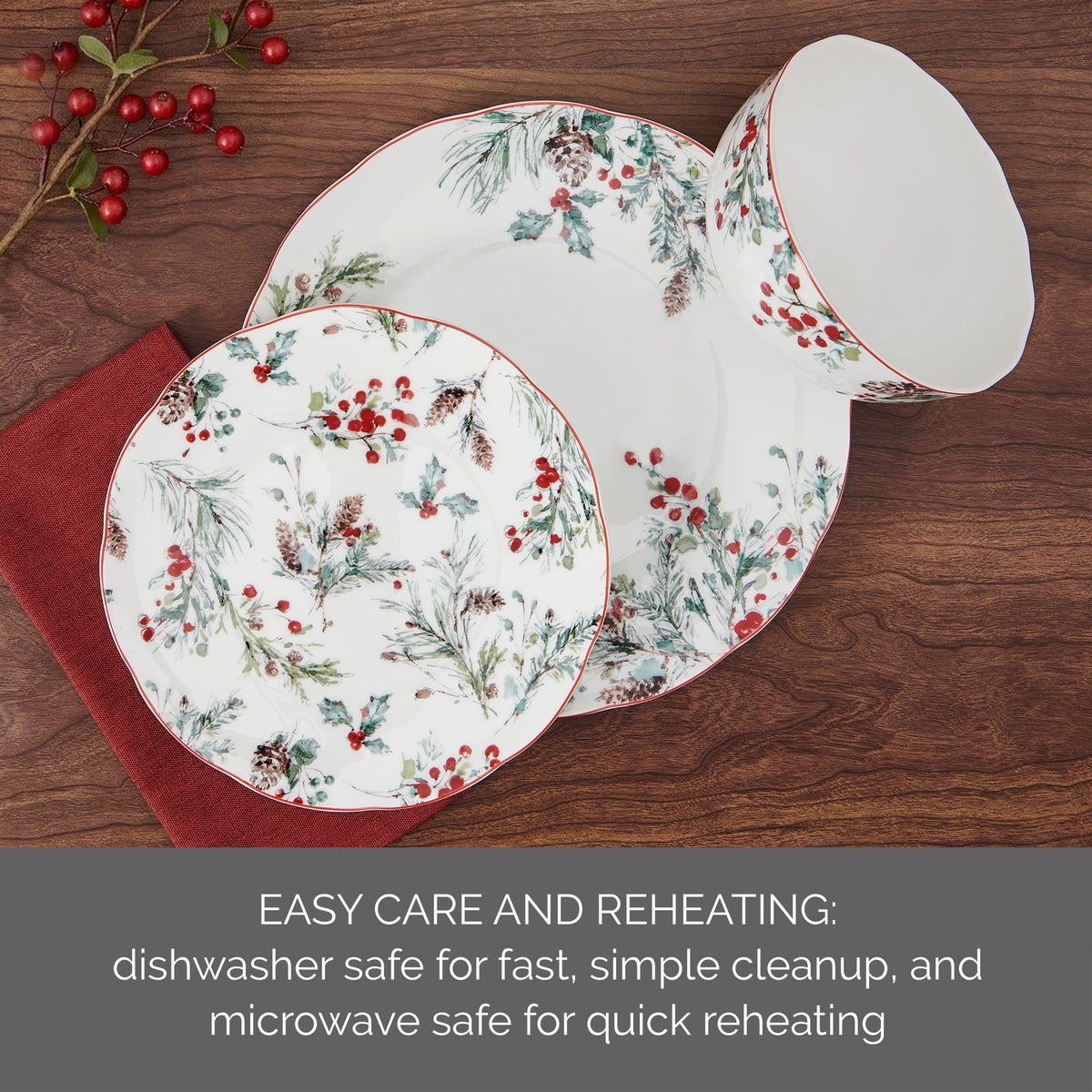 Pine and Berry dinnerware set arranged on a wooden table with plates and bowls featuring the festive pattern.