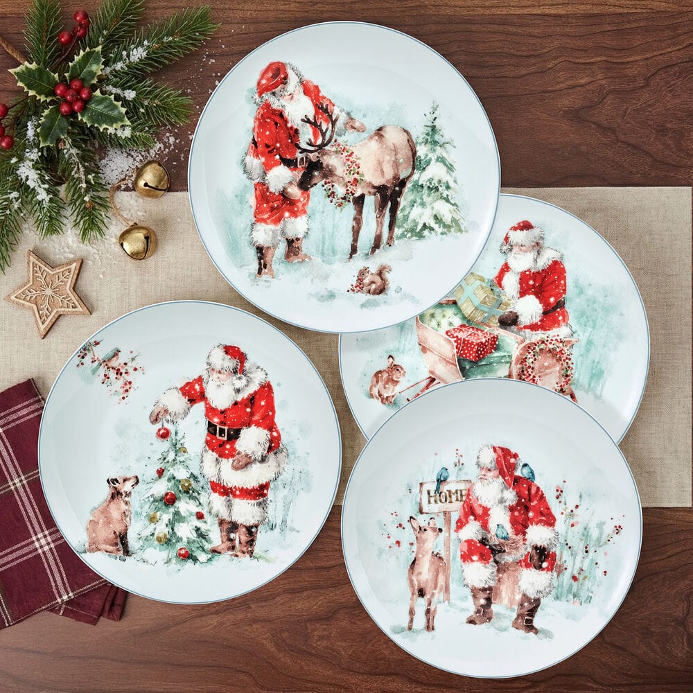 Set of four round salad plates featuring festive Santa winter scenes arranged on a wooden surface.