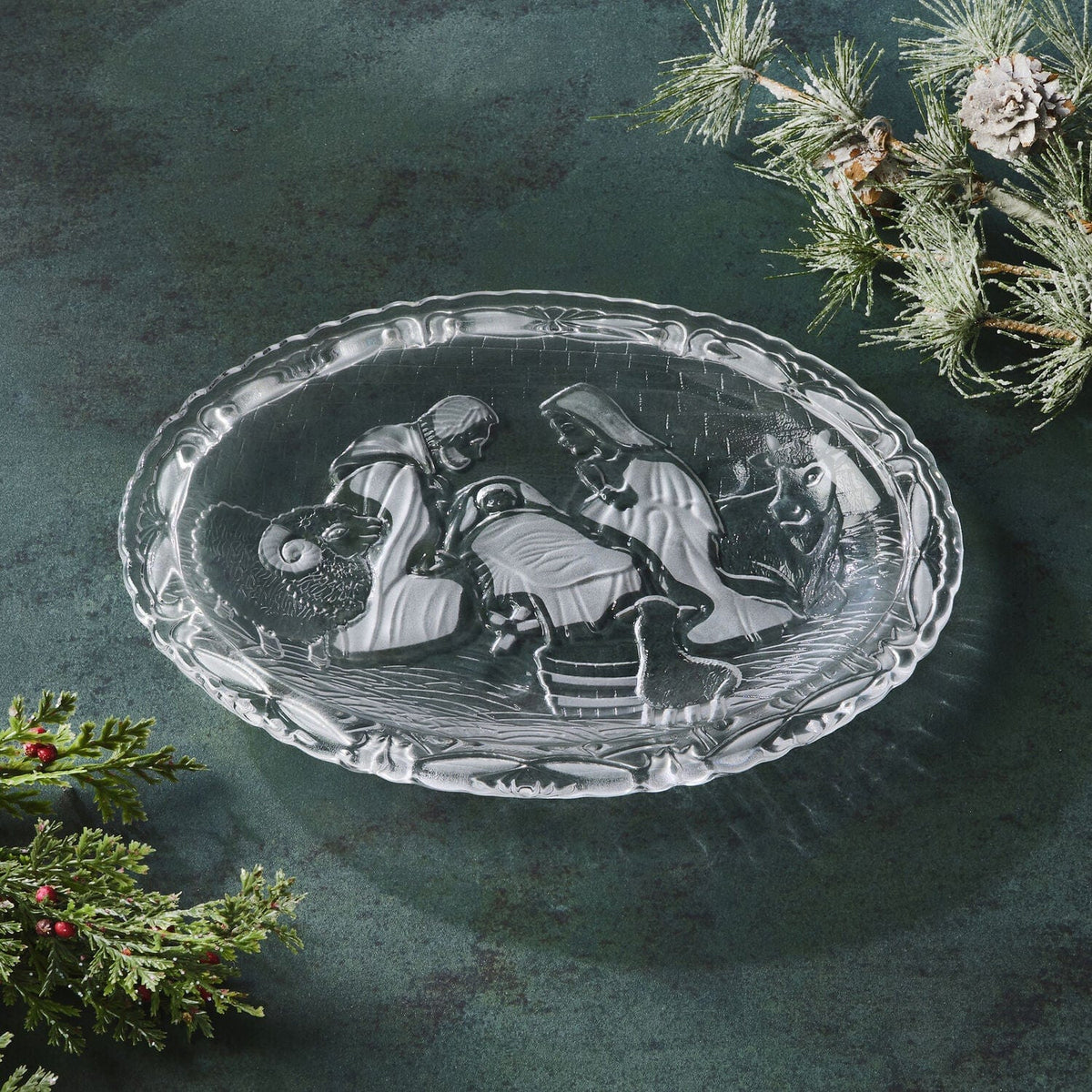 Oval crystal nativity plate with stand featuring Mary Joseph and baby Jesus with animals against a teal backdrop