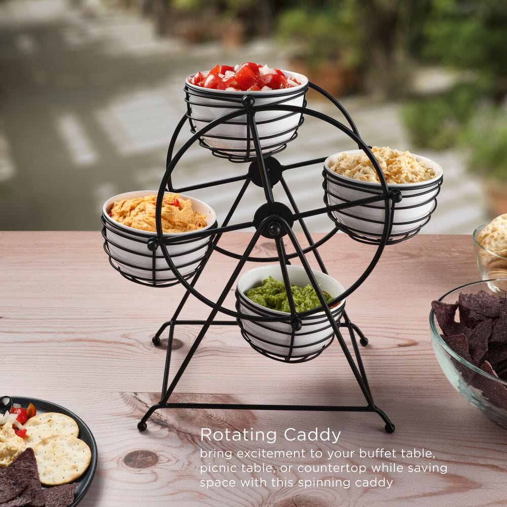 Rotating ferris wheel style appetizer caddy on a wooden table with bowls of dips and toppings.