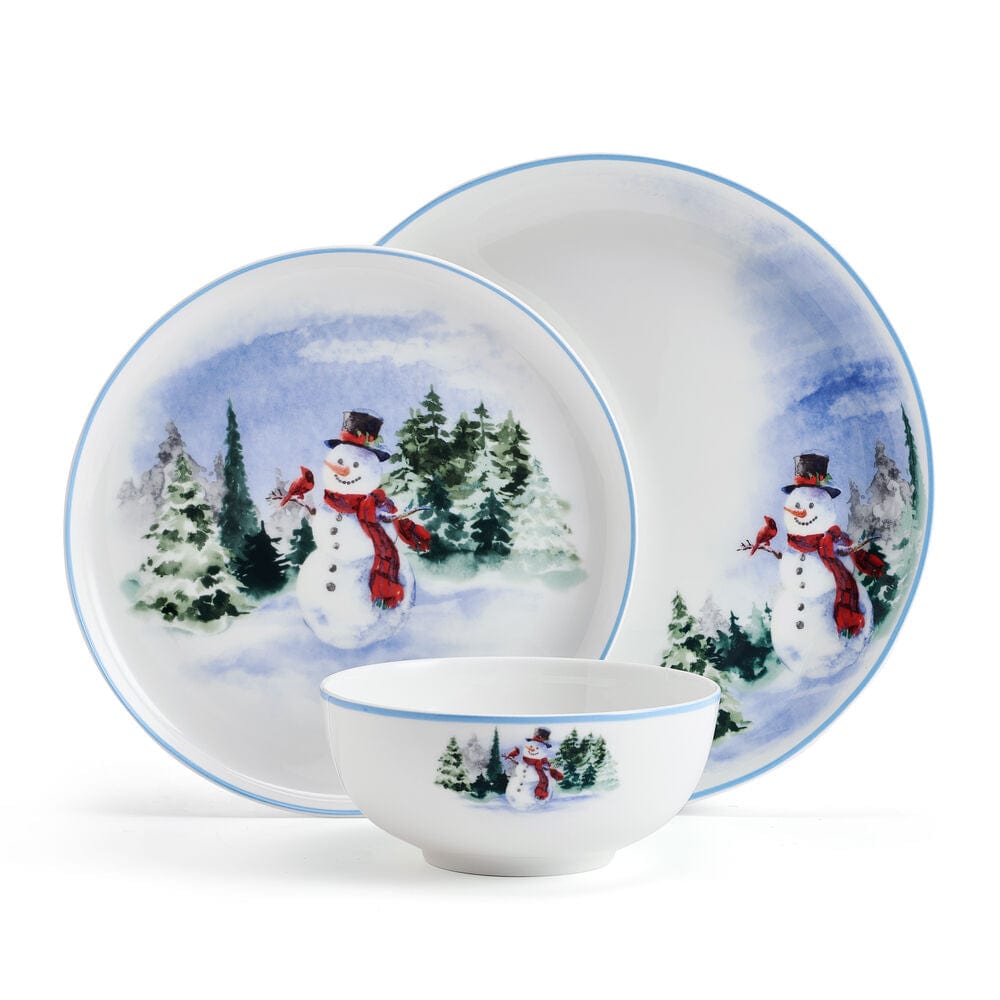 Snowman Forest dinnerware set for four with a snowy forest scene on plates and a small bowl.