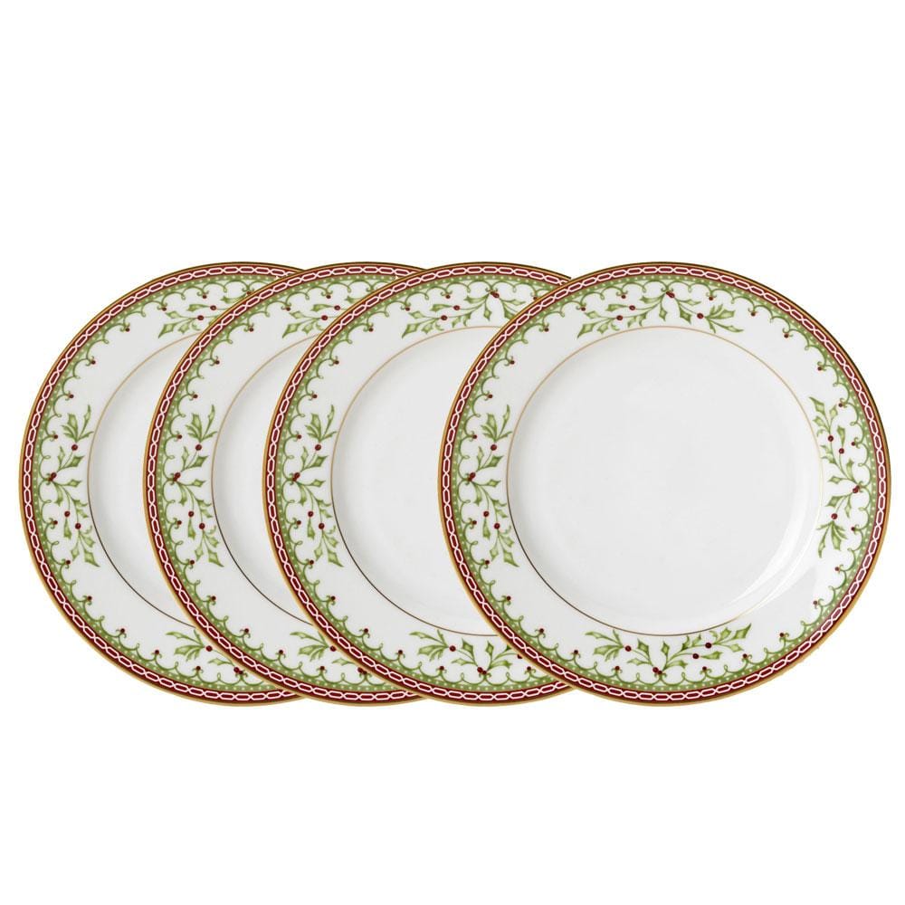 Four white ceramic plates with a green holly and red berries border pattern, arranged in a staggered stack on a white background.
