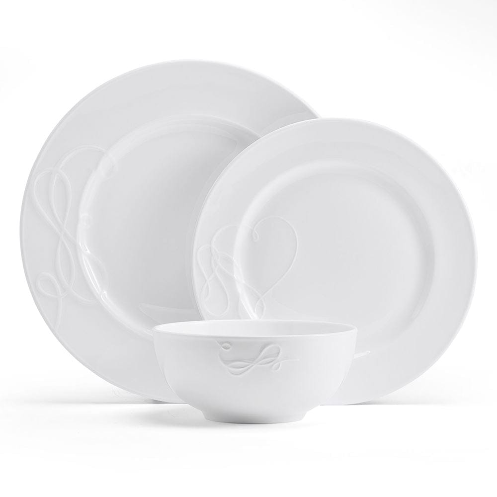 White ceramic dinnerware set with embossed scroll pattern on plates and a bowl