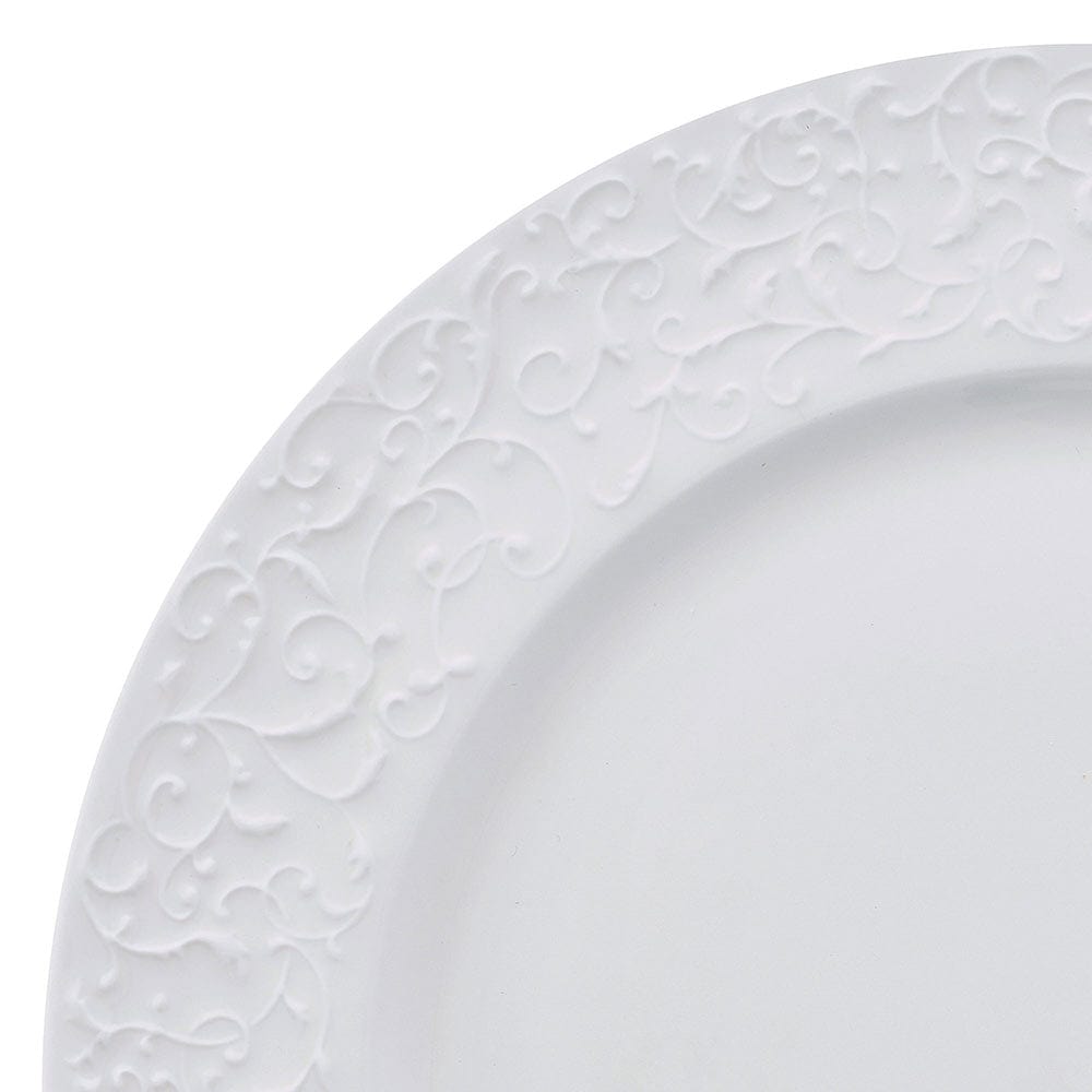 Close-up of white plate edge with embossed scroll pattern along the rim.