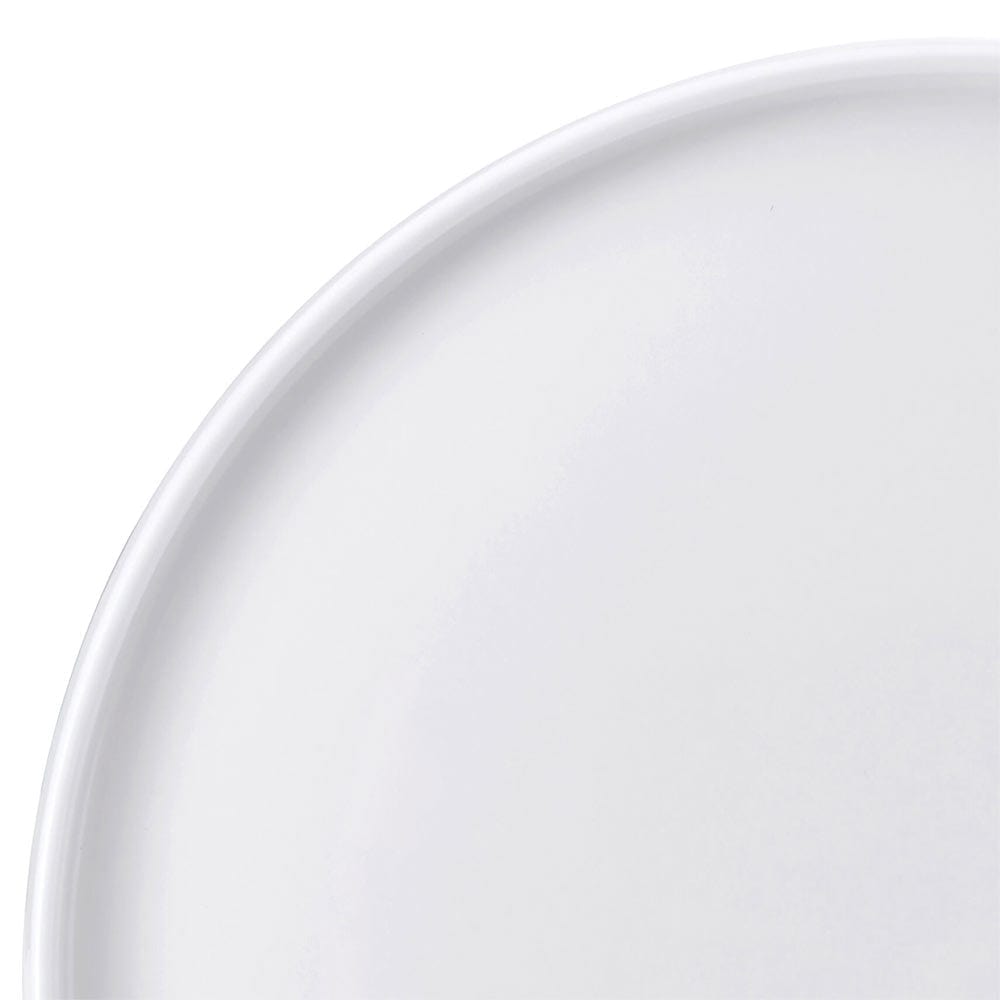 Close-up of the curved rim of a white dinner plate from the Sloane set.